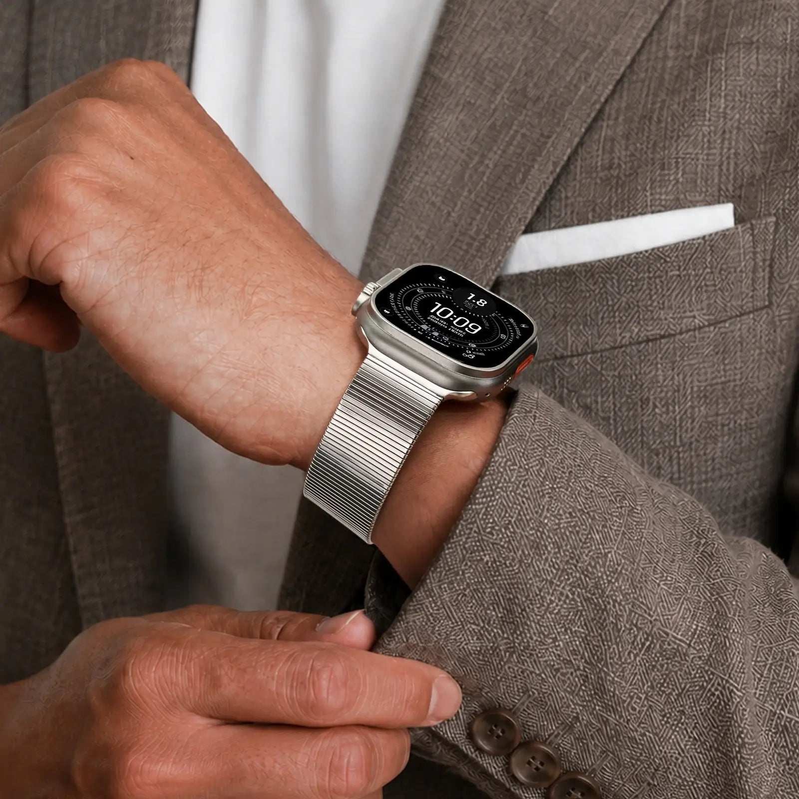 Person wearing a smartwatch on a brown suit jacket