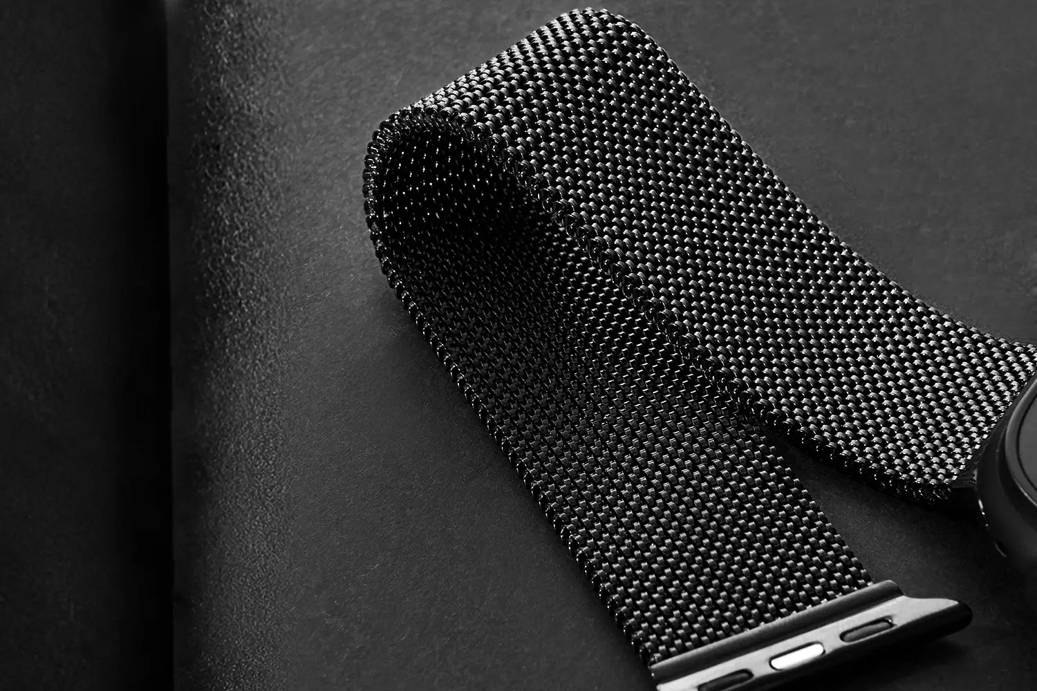 Black mesh watch band on a smartphone with a dark background