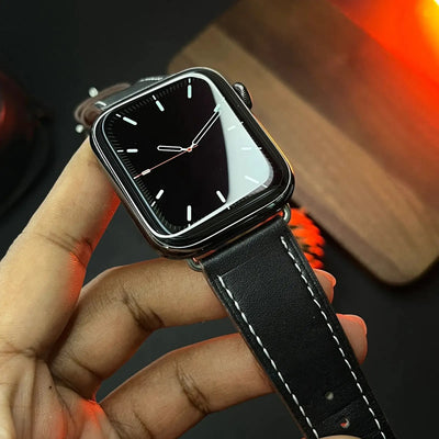 Black smartwatch held in a hand against a blurred background
