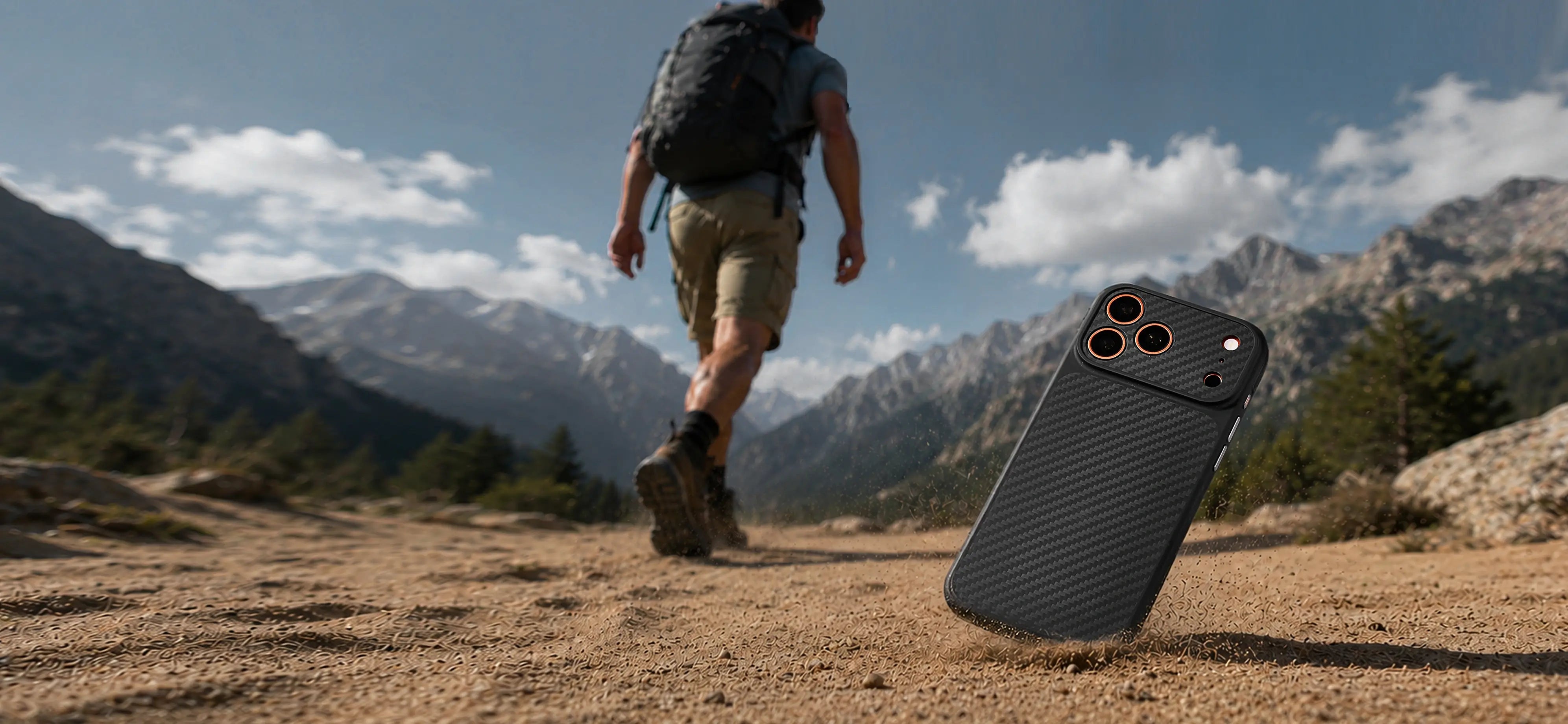 Person hiking in a mountainous area with a backpack, and a phone case on the ground.