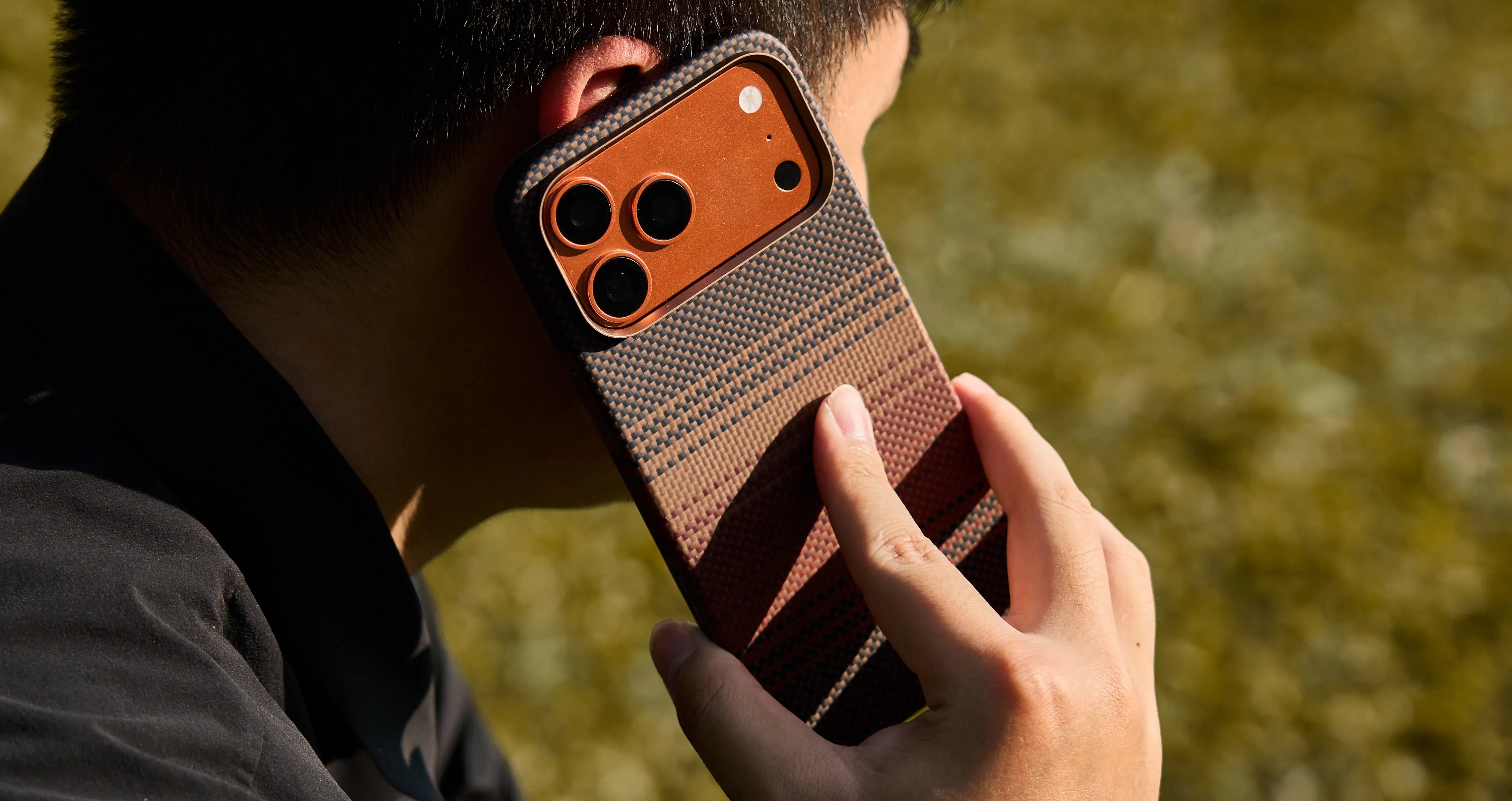 Person holding a phone with a patterned case outdoors