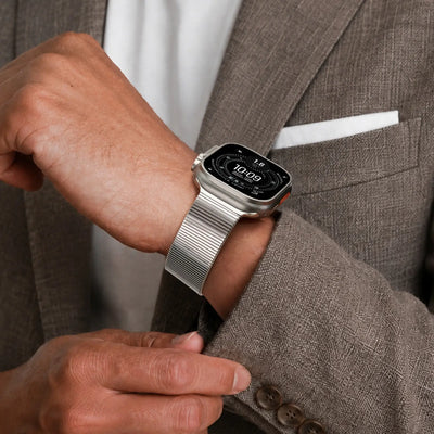 Person wearing a smartwatch on a brown suit jacket