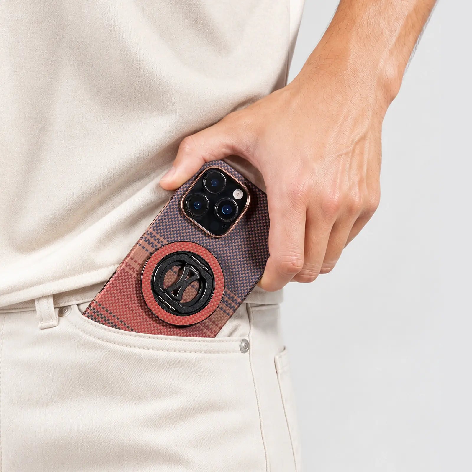 Person holding a phone with a textured case against a light background