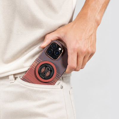 Person holding a phone with a textured case against a light background