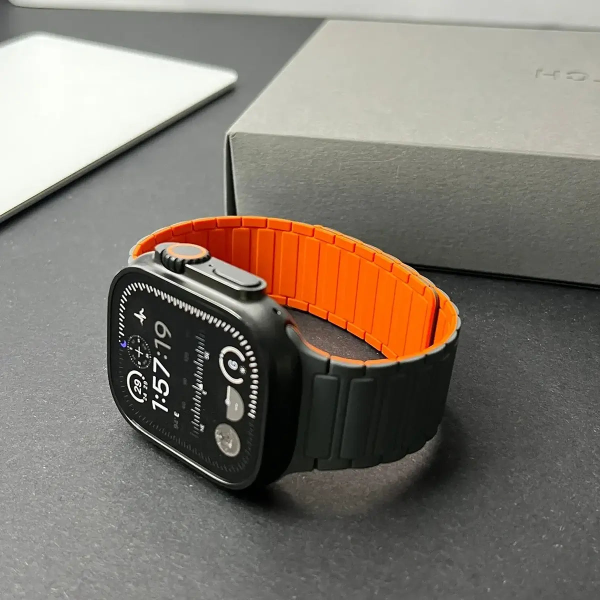 Smartwatch with an orange band on a gray surface