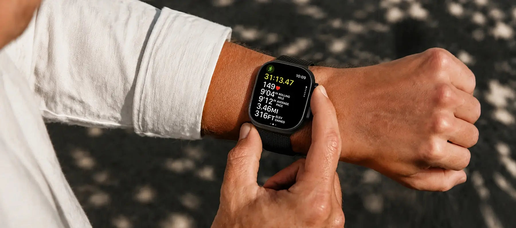 Person wearing a black smartwatch on a gray background
