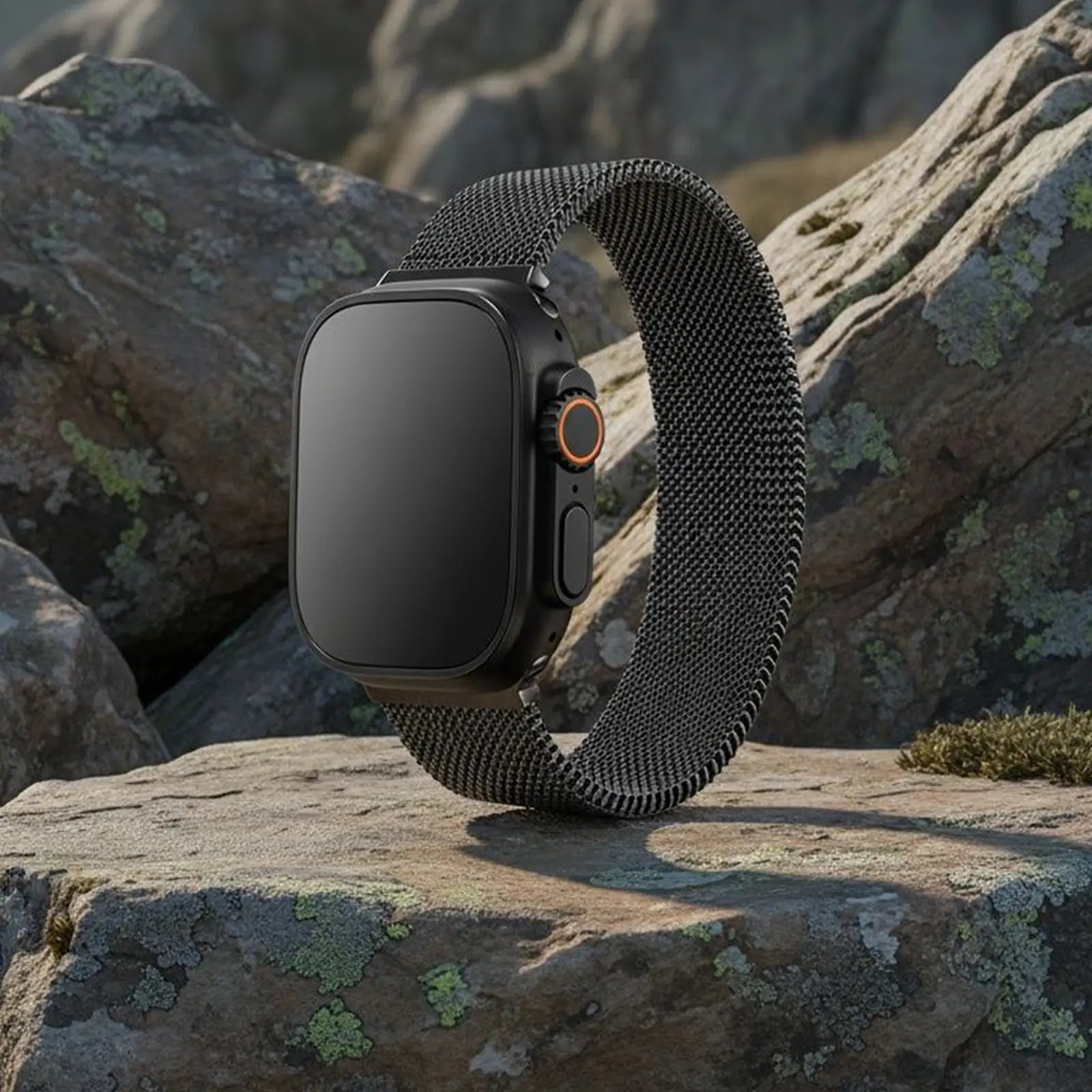 Smartwatch with a black mesh band on a rocky surface