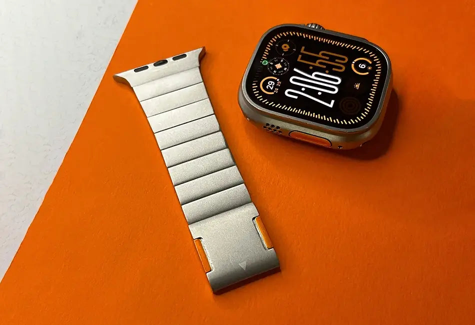 Smartwatch with metal band on an orange surface