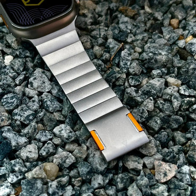 Smartwatch with a metallic band on a bed of small stones