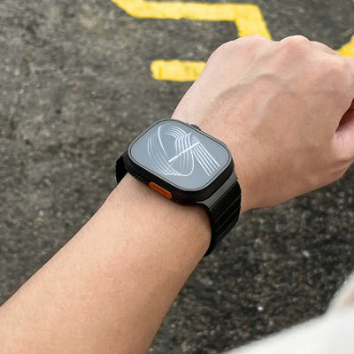 Person wearing a black smartwatch on a textured surface